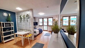 Un salon moderne comprenant un coin repas, un lit et un grand miroir.