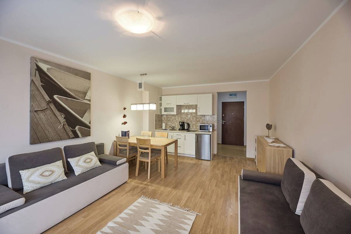 A compact living space with a sofa, a dining table, and a kitchenette.