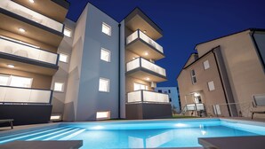 A modern building with multiple balconies and a swimming pool. - Poolside Hideout Apartments (Novalja)