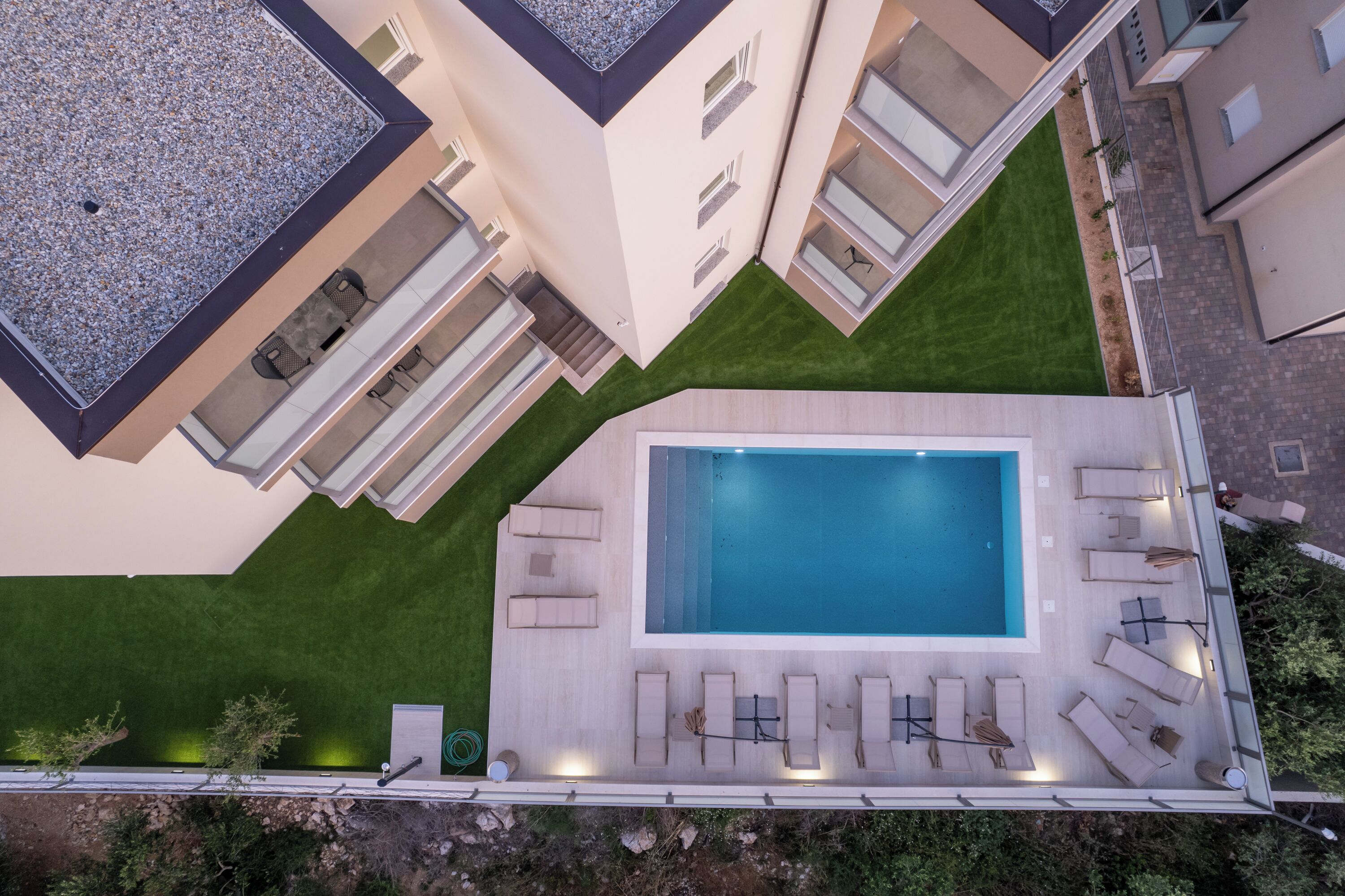 A rooftop pool area with multiple lounge chairs and a rectangular pool.