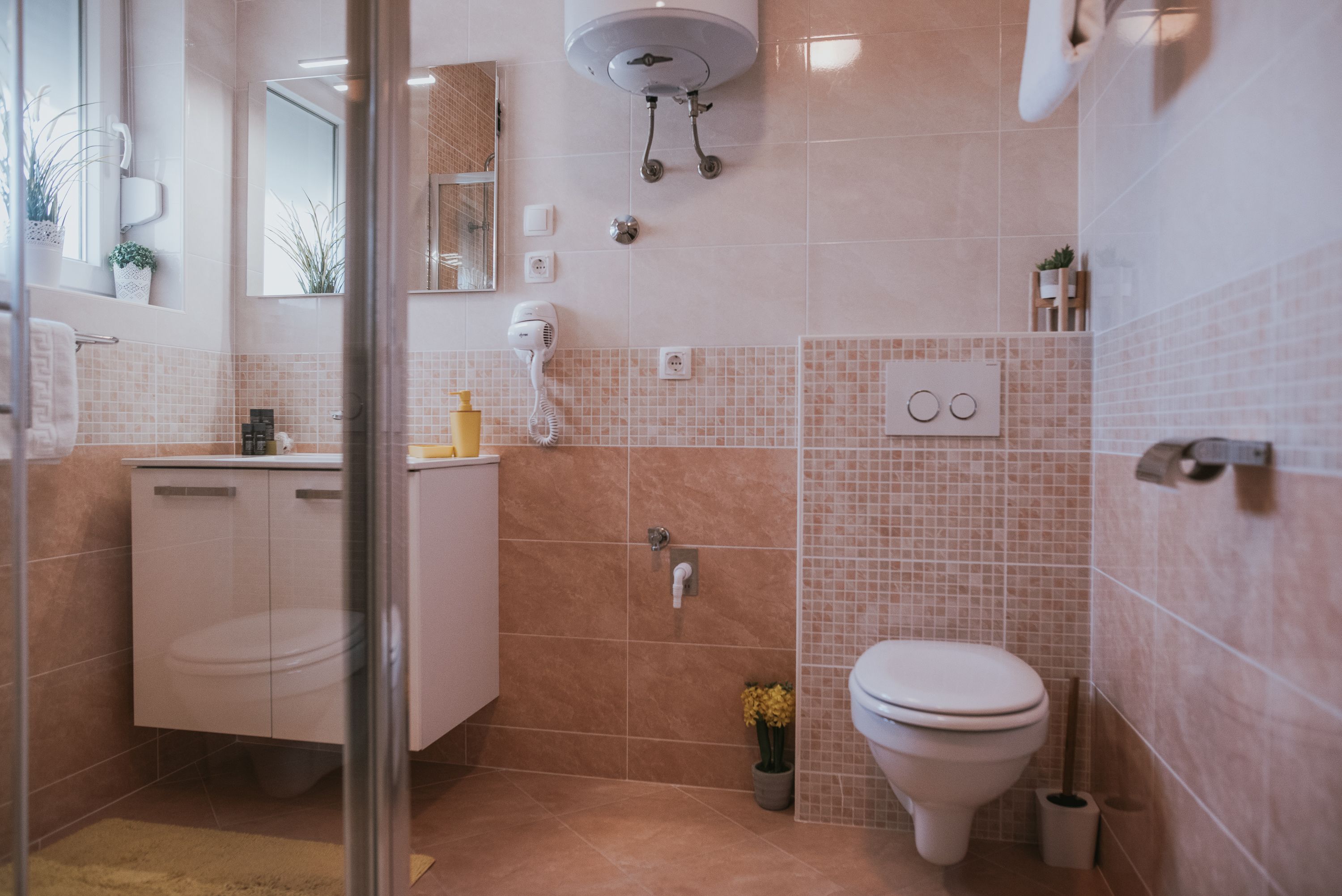 Ein modernes Badezimmer mit Toilette, Waschbecken und Dusche.