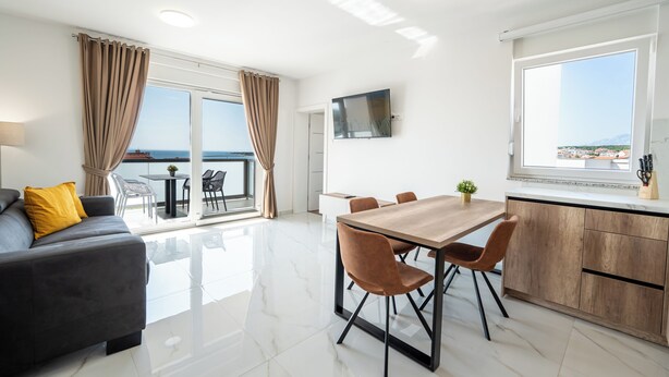 A modern hotel room with a balcony, a dining area, and a kitchen. - Poolside Hideout Apartments (Novalja)