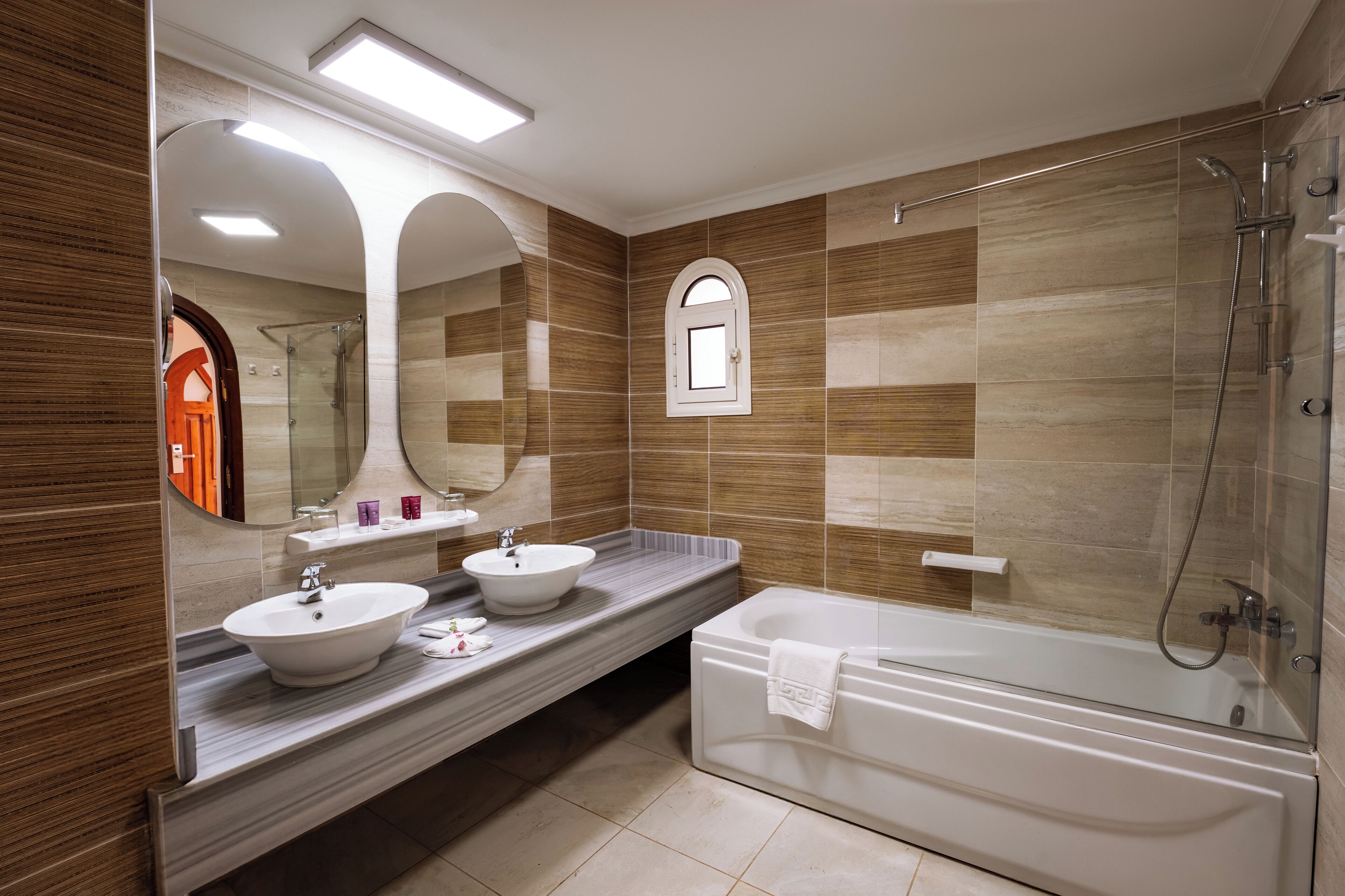 Un bagno moderno con uno specchio grande, due lavabi, una vasca e una doccia.