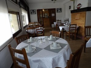 A dining area with round tables, chairs, and white tablecloths. - Logis Hôtel de l'Artuby (Séranon)
