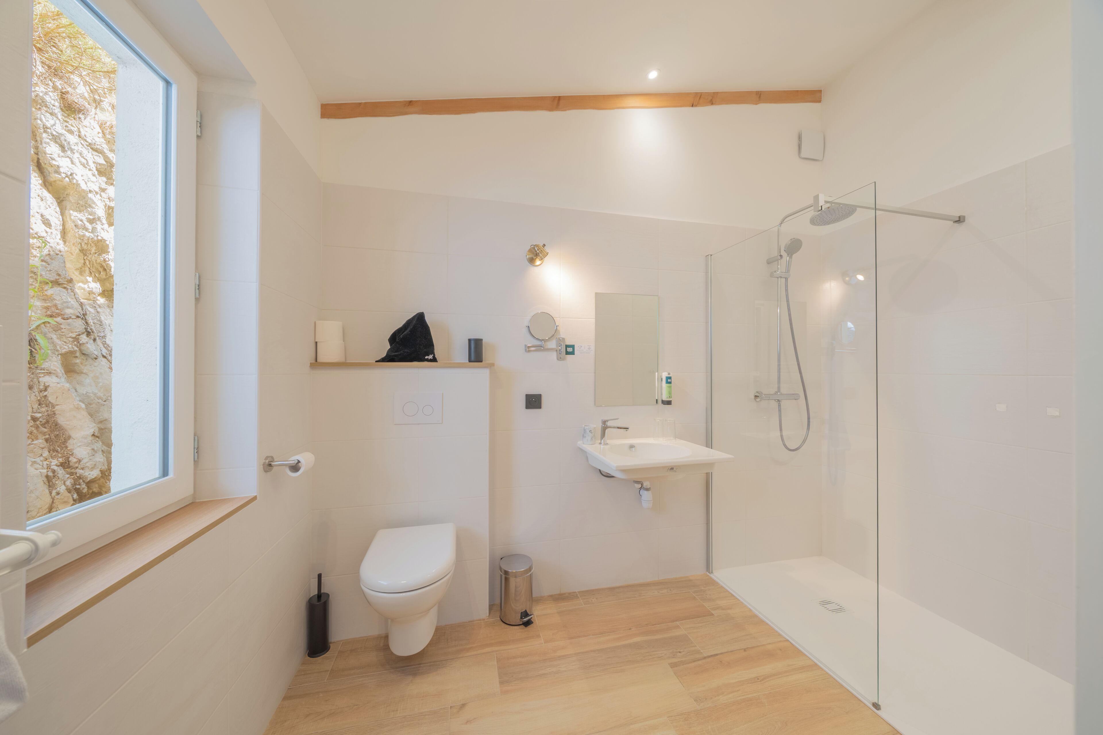 Un baño moderno con inodoro, lavamanos y ducha.
