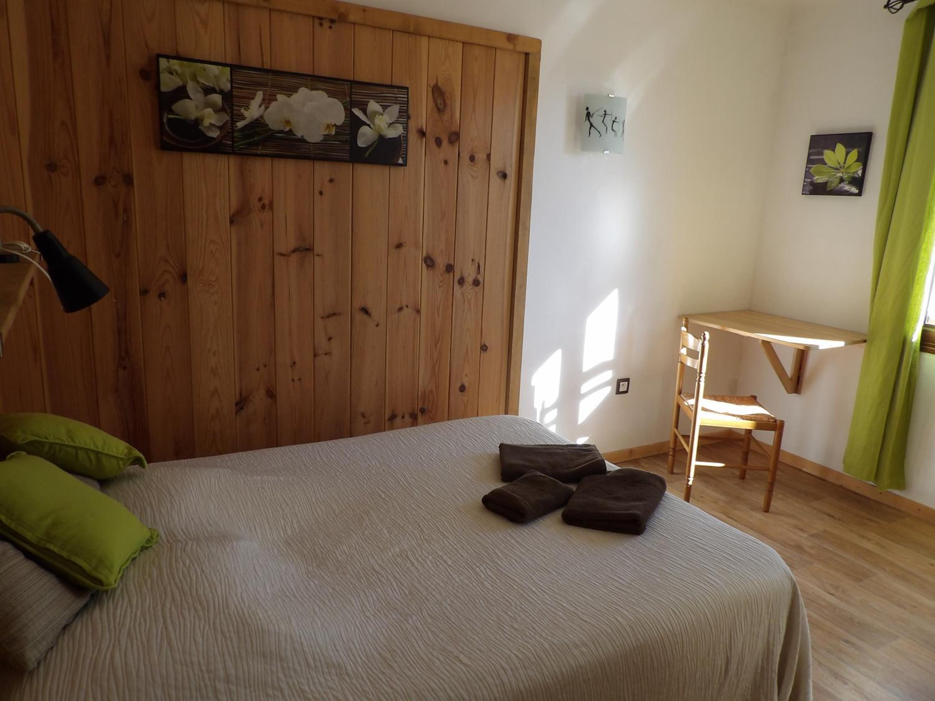 Un dormitorio con una cama, un escritorio y una silla.