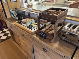 Un bufé de desayuno con diferentes alimentos y una máquina de café.