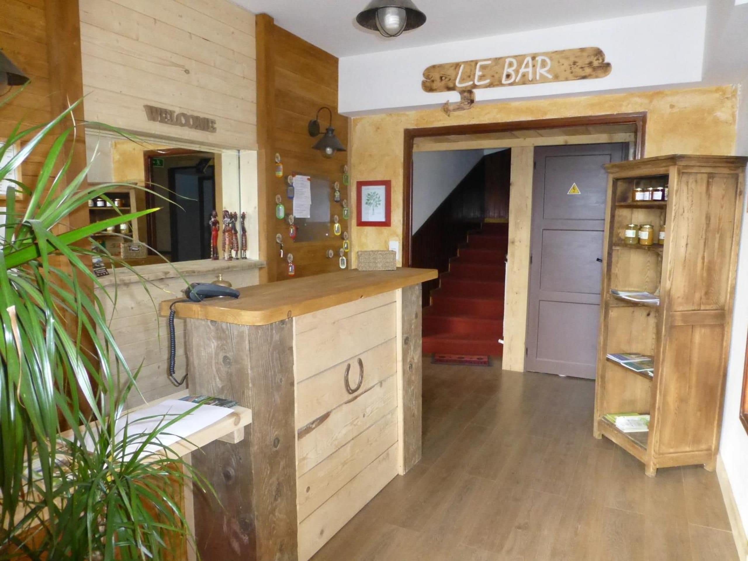 Een houten interieur met een receptiebalie, een trap en een bar.