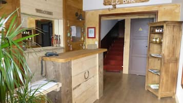Een houten interieur met een receptiebalie, een trap en een bar.