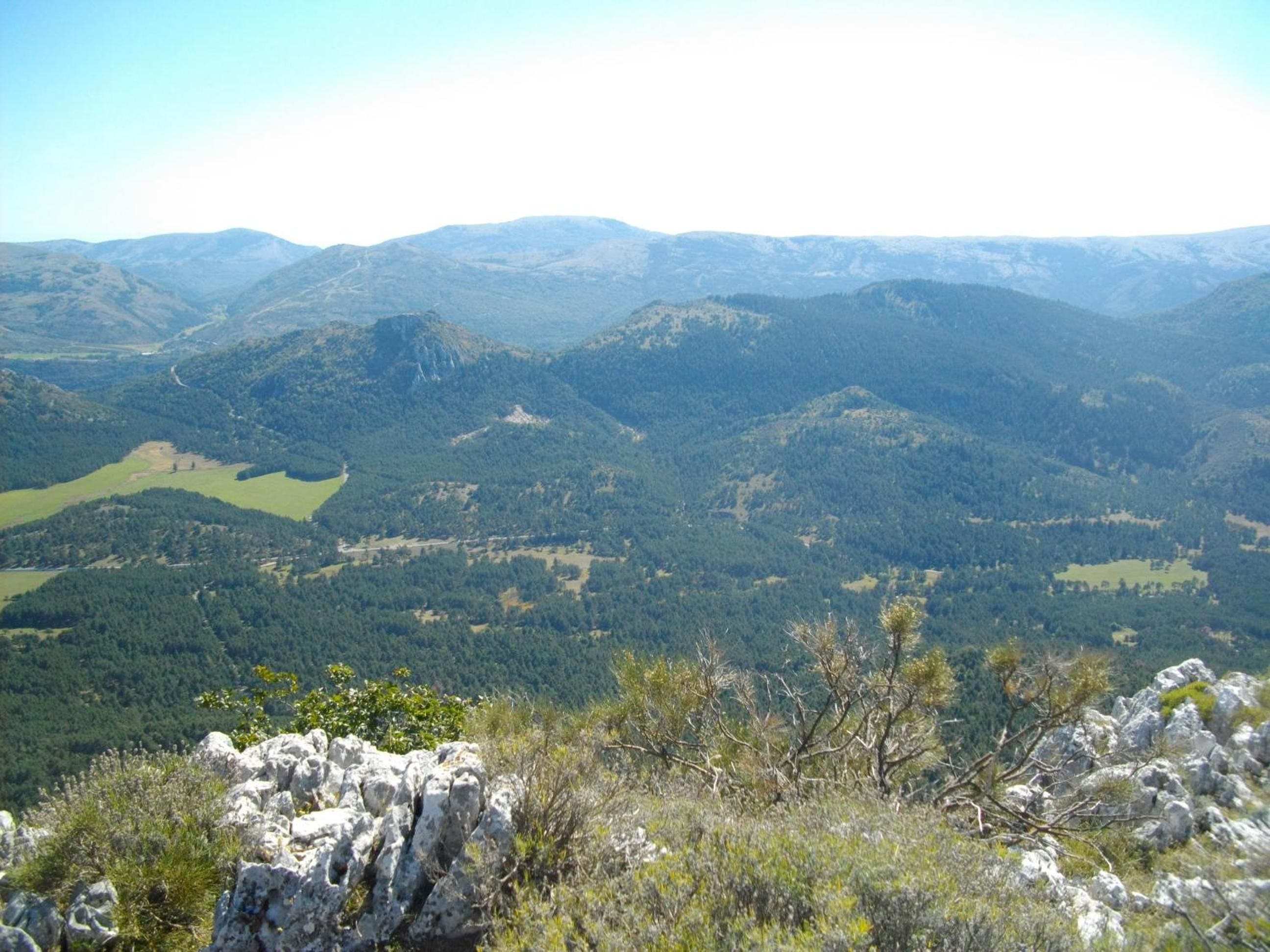A mountainous landscape with a valley and a lake.