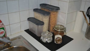 A kitchen counter with containers of grains, a jar of honey, and a bottle of dish soap. - Abbey Street City Centre Apartment (Dublin)