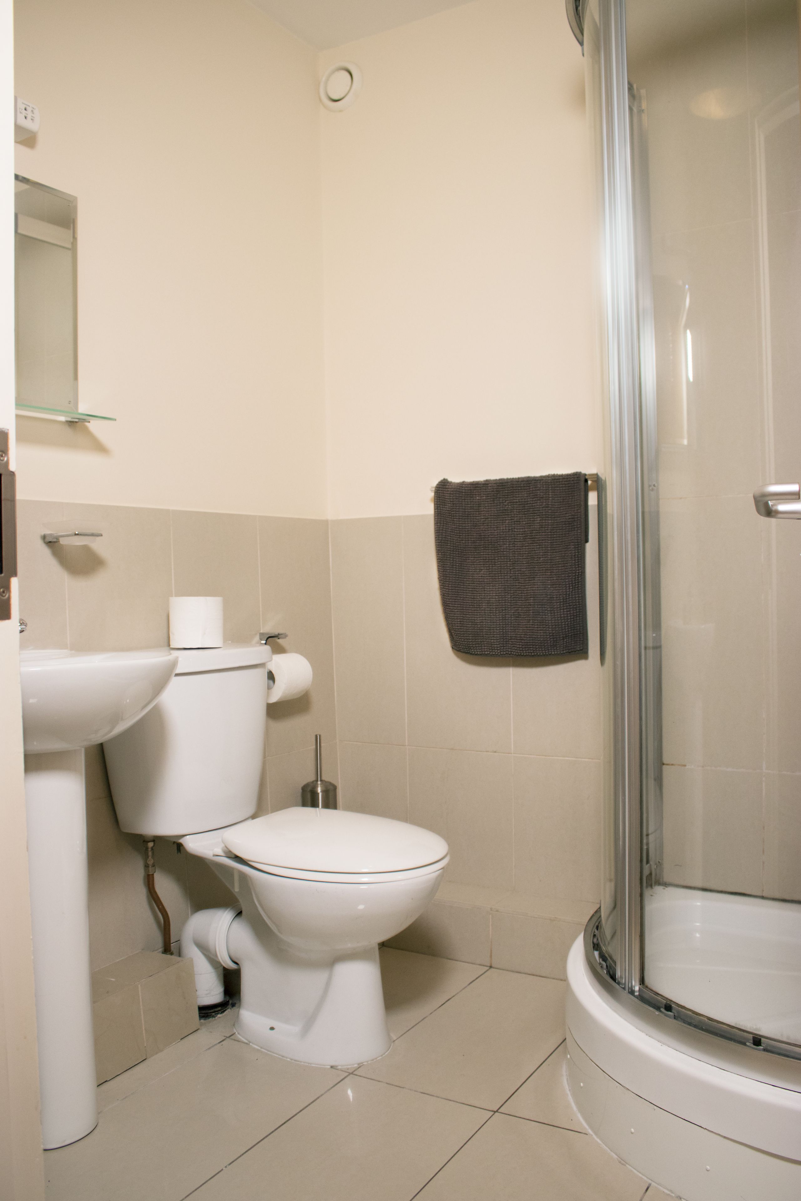 A bathroom with a toilet, sink, and shower.