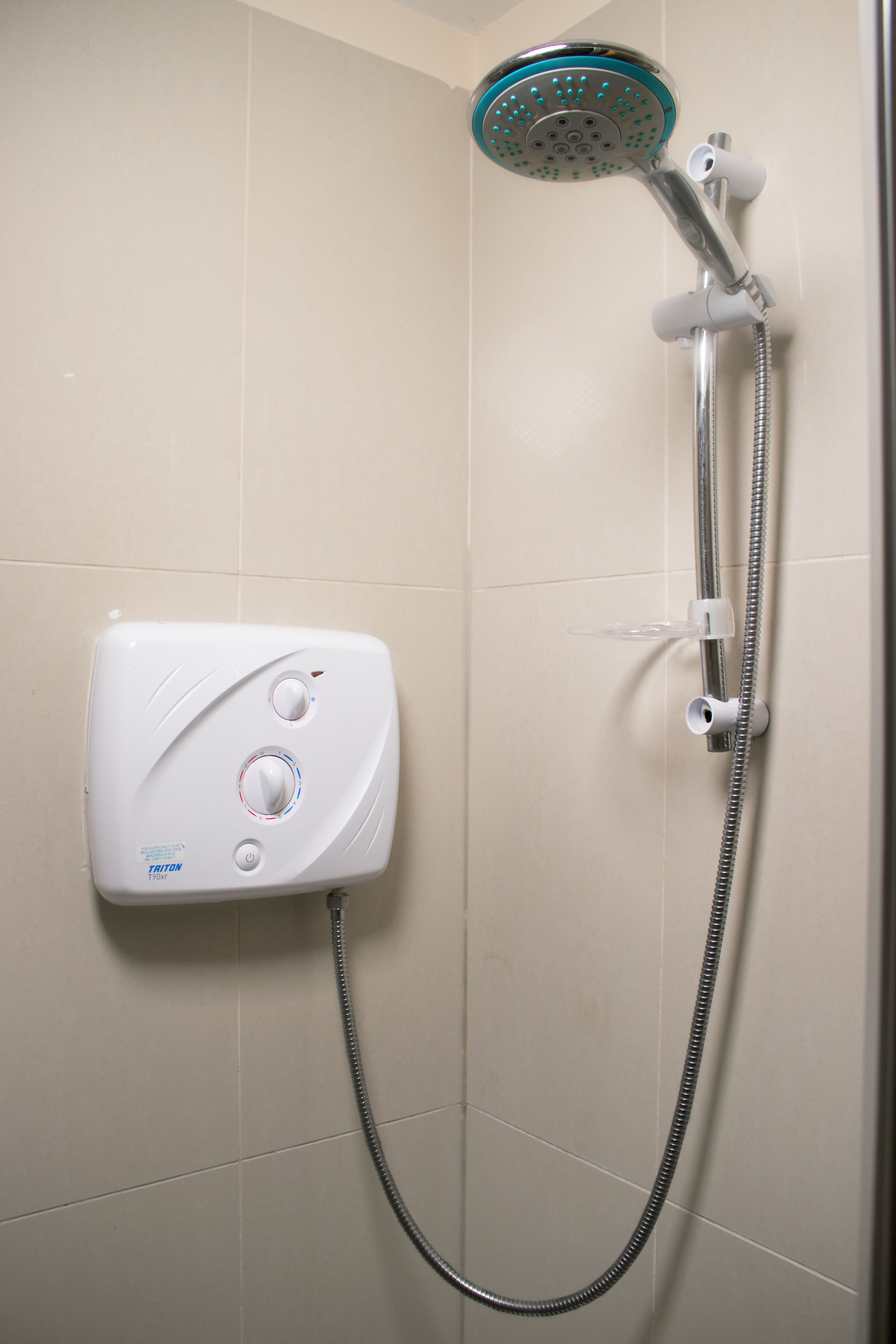 Eine Dusche mit Handbrause und einer fest installierten Bedienfeld.