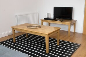 Departamento urbano, varias camas | Área de sala de estar | Televisión LCD de 42 pulgadas con canales digitales y televisión