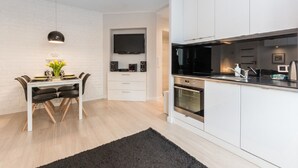 Une cuisine moderne avec des meubles blancs, un plan de travail noir et des appareils électroménagers intégrés.