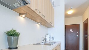 A modern kitchen with a built-in stove, a coffee maker, and a potted plant.