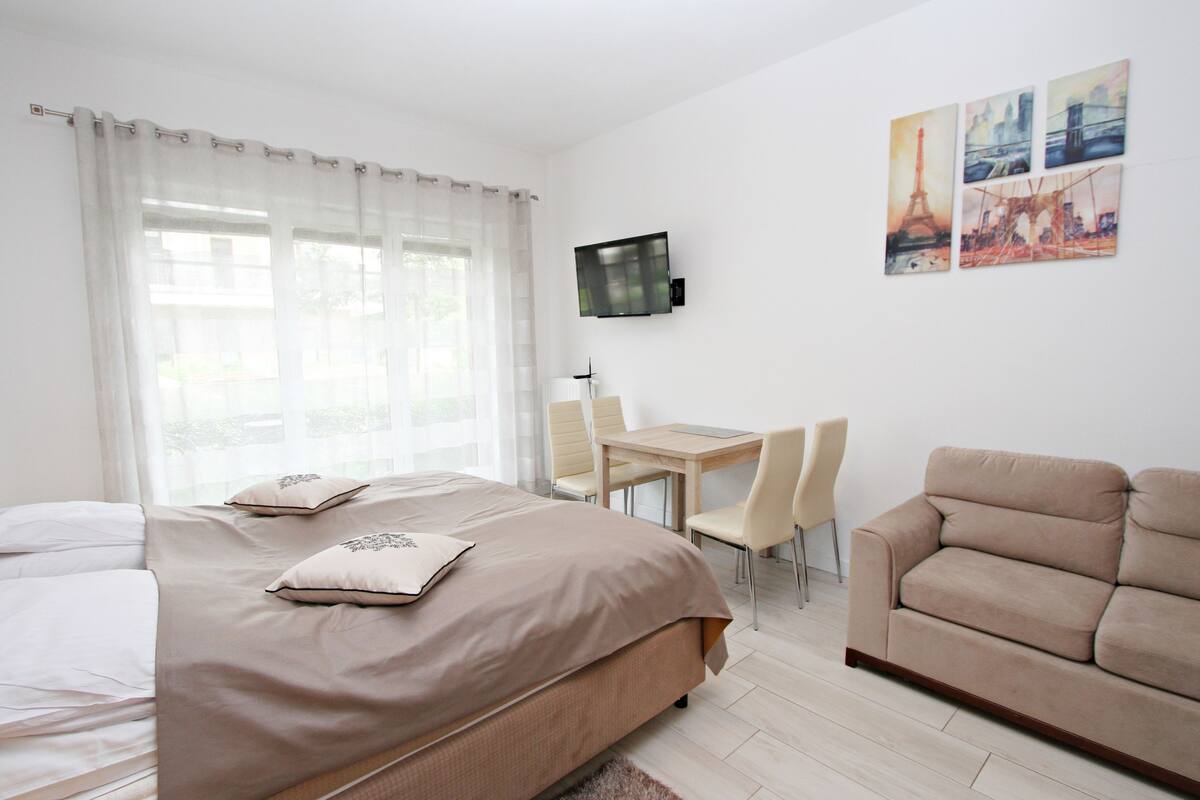 Una habitación de hotel con cama, escritorio, silla y sofá.