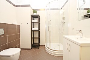 Standaard studio suite, op benedenverdieping | Badkamer | Een douche, handdoeken, toiletpapier