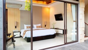 A modern bedroom with a large bed, a TV mounted on the wall, and a sliding glass door leading to a balcony. - La Paradis Villa (Pererenan)