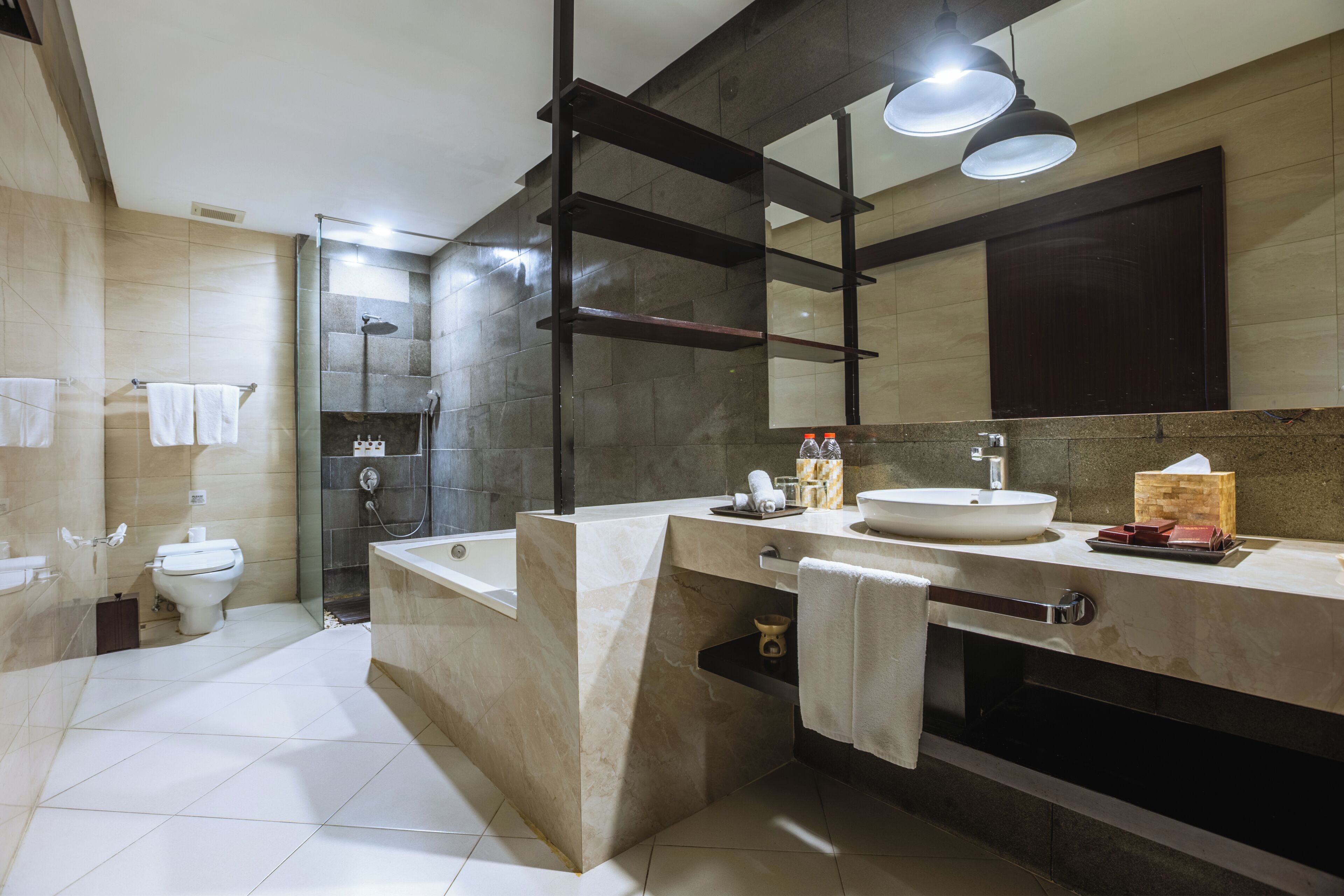 Un baño moderno con un espejo grande, una bañera, un inodoro y una ducha.