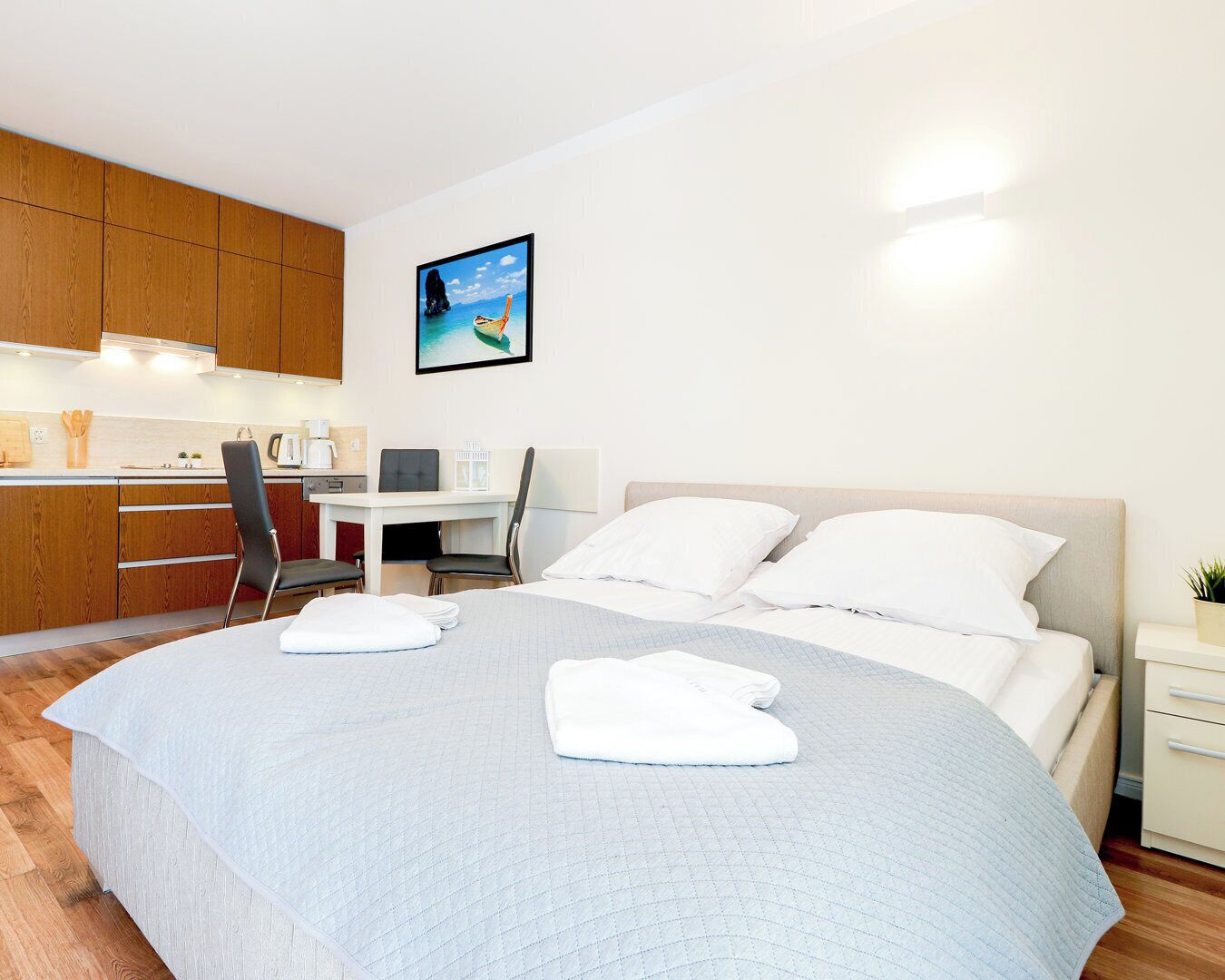 Een moderne hotelkamer met een groot bed, een bureau en een kitchenette.
