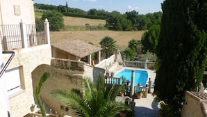 Une villa avec une façade en pierre, une piscine et une vue sur un paysage rural.