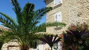 Un bâtiment en pierre doté d’un balcon et d’un panier de basketball dans la cour.