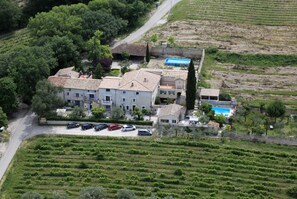 A large building with multiple floors, surrounded by terraced vineyards, and a swimming pool. - Le Saint Victor (Mirabel-aux-Baronnies)