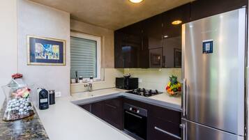 Deluxe Apartment, 2 Bedrooms | Private kitchen | Coffee/tea maker, full-size fridge, microwave, oven