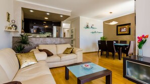 Ein Wohnzimmer mit Sofa, Couchtisch und Essbereich mit Stühlen und Tisch.