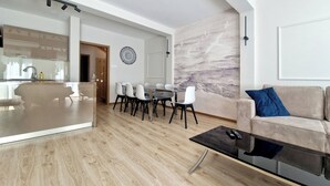 A modern living room with a dining area, wooden flooring, a sofa, and a coffee table. - Holiday House by Baltic Home (Swinoujscie)