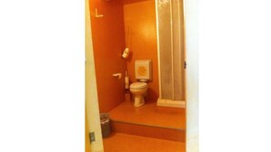 A bathroom with a toilet, a sink, and a shower area. - Cadoro (Venice)