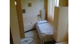 A narrow hallway with a bed and a radiator in the corner. - Cadoro (Venice)