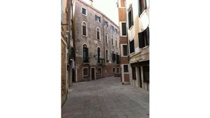 A narrow street with buildings on either side. - Cadoro (Venice)