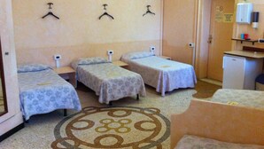 A hotel room with three single beds, a small kitchenette, and a bathroom. - Cadoro (Venice)