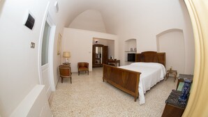 A bedroom with a wooden bed, a small desk, a chair, and a TV. - B&B Casa Catalano (Terlizzi)