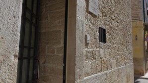 A stone building with a window and a small sign on the wall. - B&B L' alcova (Terlizzi)