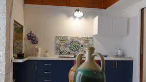 A kitchen with blue cabinets, a white countertop, and a decorative backsplash. - B&B L' alcova (Terlizzi)