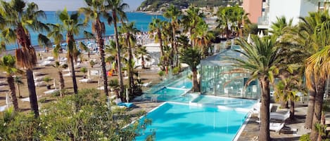 Una piscina cubierta, una piscina al aire libre de temporada, sombrillas