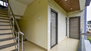 A modern building with a staircase, two doors, and a balcony. - Treebo Prince Palace With Swimming Pool (Mahabaleshwar)