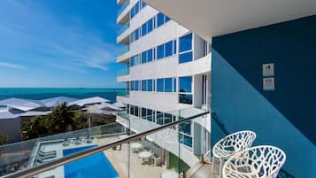 Alberca al aire libre, sombrillas en la alberca y camastros