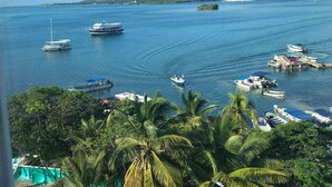 A marina with various boats docked, surrounded by lush greenery and a clear blue sky. - Samawi (San Andrés)