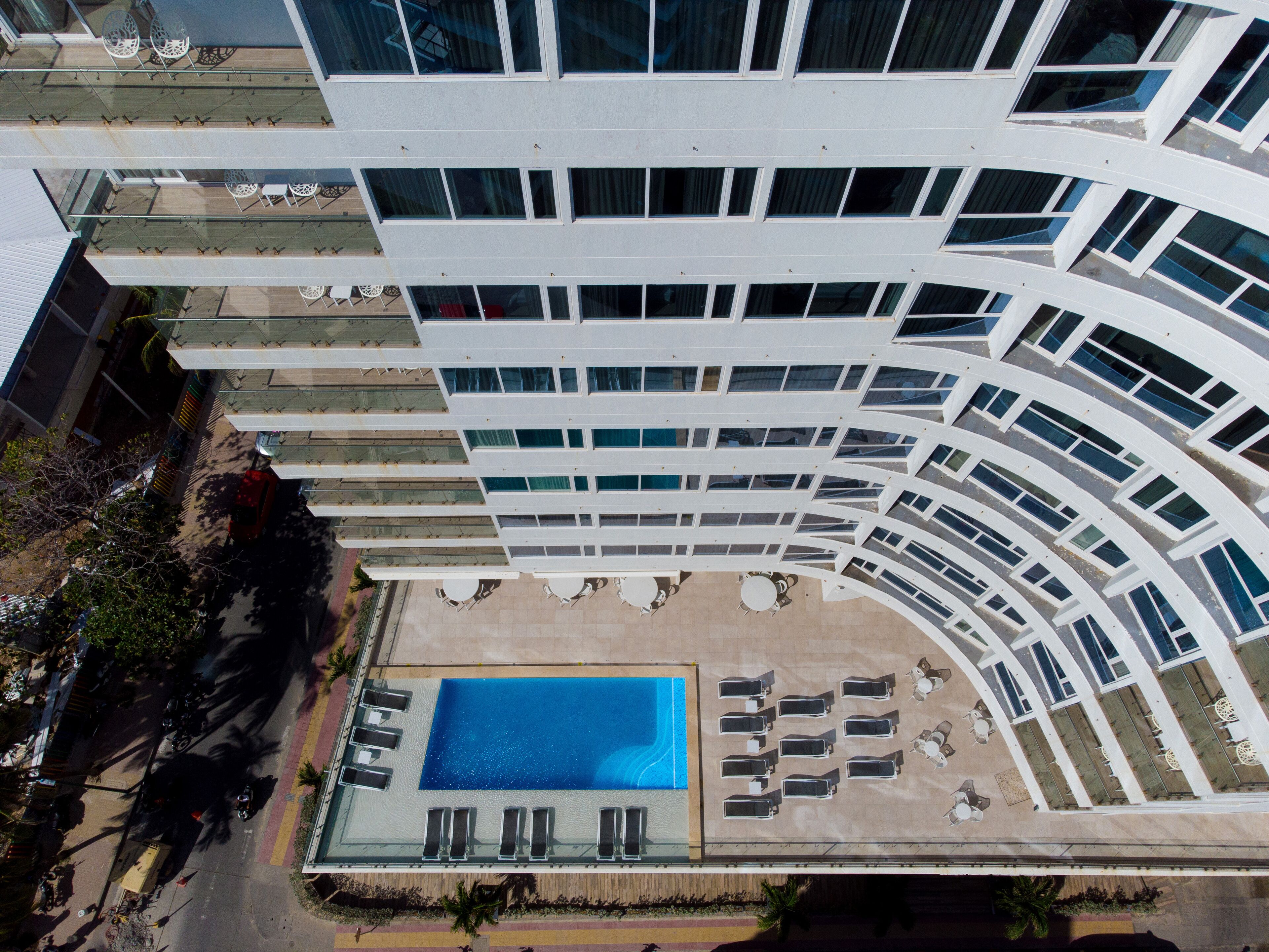 A modern building with a rooftop pool and outdoor seating.