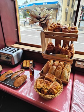 A bakery display with various baked goods, a toaster, and a window view of a street. - Hotel Terminus - Pizzeria Pizz'A Gogo (Lons-le-Saunier)