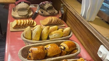 Un bufé de desayuno con panes y bollería variada.