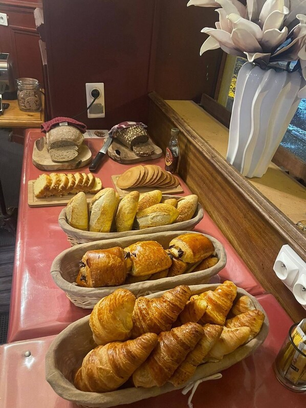 Un bufé de desayuno con panes y bollería variada.