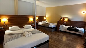 Una habitación de hotel con dos camas, cabeceros de madera y lámparas de noche.