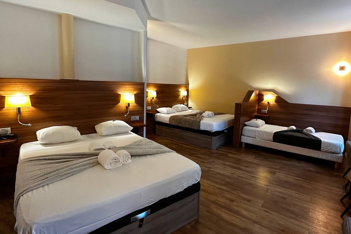 Ein Hotelzimmer mit zwei Betten, Holz Kopfteilen und Nachttischlampen.
