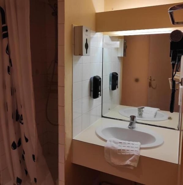 A bathroom with a sink, mirror, and towel rack. - Hotel Terminus - Pizzeria Pizz'A Gogo (Lons-le-Saunier)