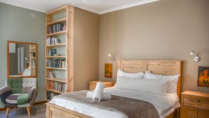 Un dormitorio con una cama de madera, una estantería, una silla y una mesita de noche.